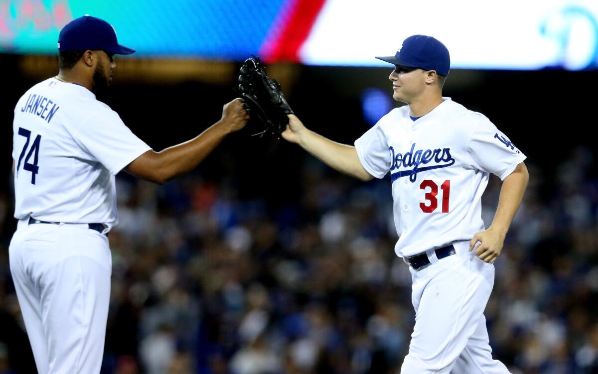 Closer Kenley Jansen and outfielder Joc Pederson celebrate after the Dodgers' 2-1 victory over the San Diego Padres on Friday at Dodger Stadium.