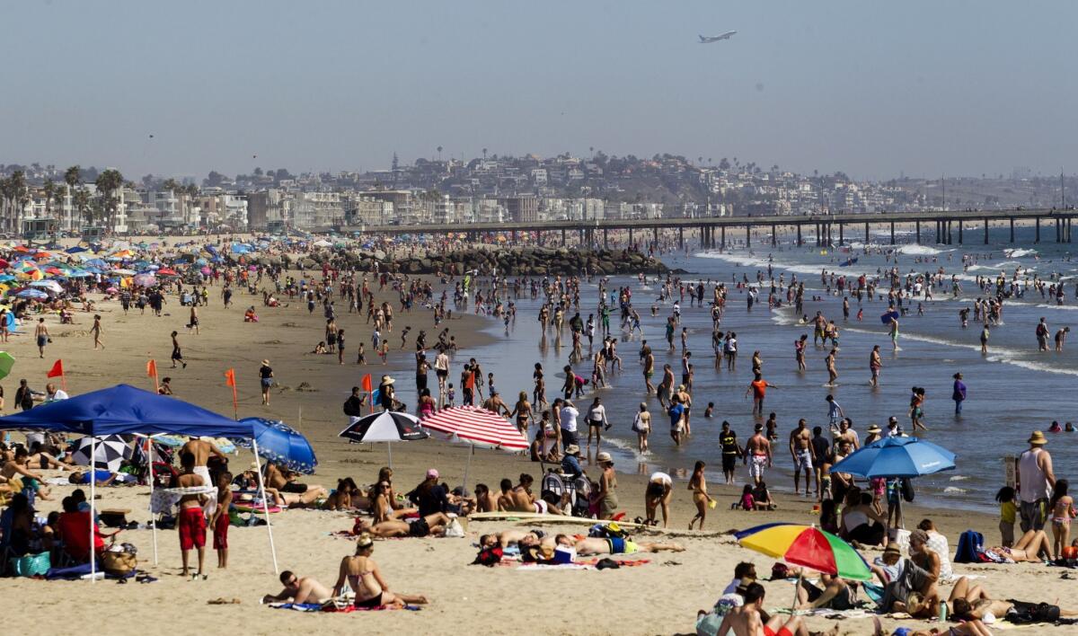 Beachgoers crowd Venice Beach, where a swimmer died Thursday after getting caught in a rip current.