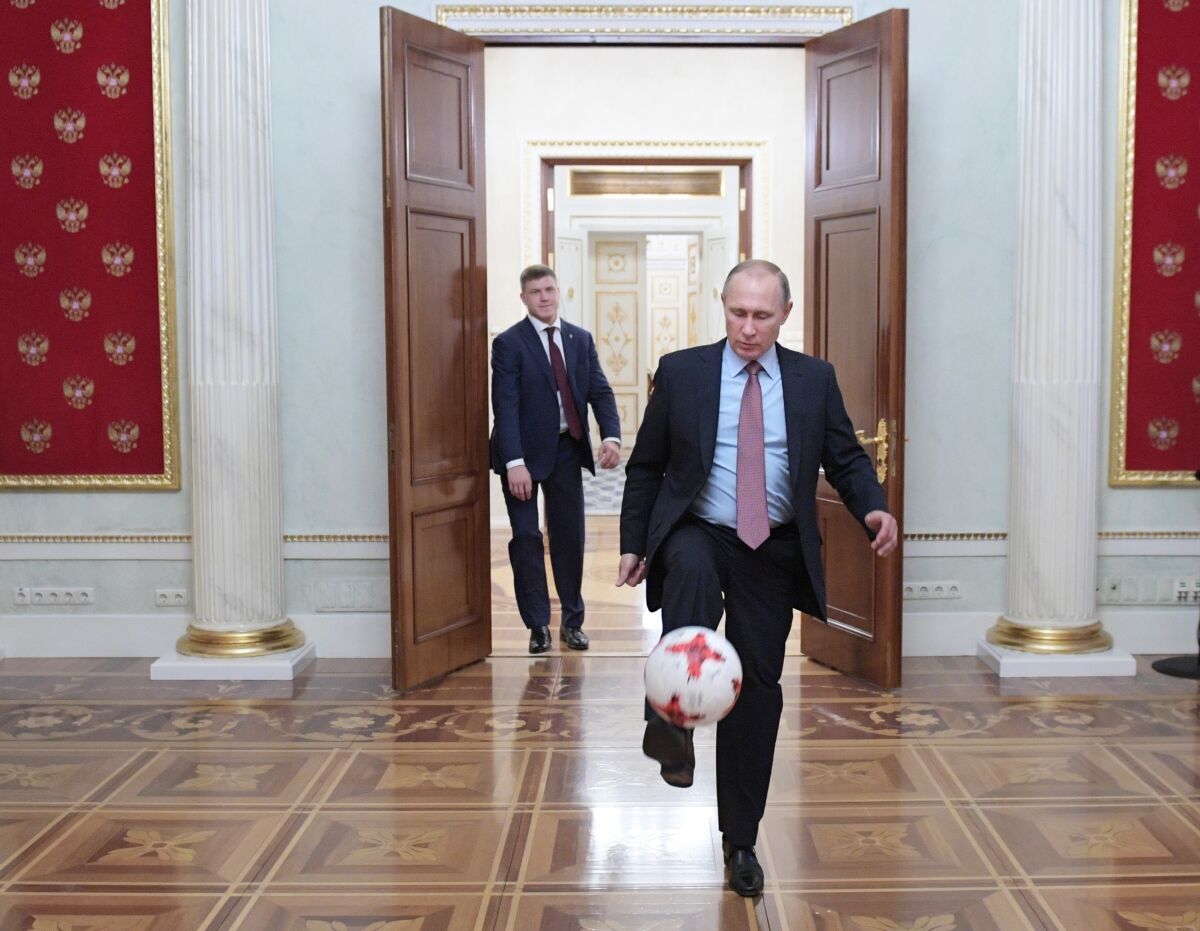 FILE - Russian President Vladimir Putin, foreground, plays with an official match ball for the 2017 FIFA Confederations Cup received from FIFA President Gianni Infantino, after their meeting in the Kremlin in Moscow, Russia, Friday, Nov. 25, 2016. Russian teams have been suspended from all international soccer, including qualifying matches for the 2022 World Cup, as Moscow was pushed toward pariah status in sports for its invasion of Ukraine. World soccer body FIFA and European authority UEFA banned Russian national and club teams from their competitions "until further notice," taking Russia's men's national team out of World Cup qualifying playoffs in three weeks' time. (Alexei Druzhinin, Sputnik, Kremlin Pool Photo via AP, File)