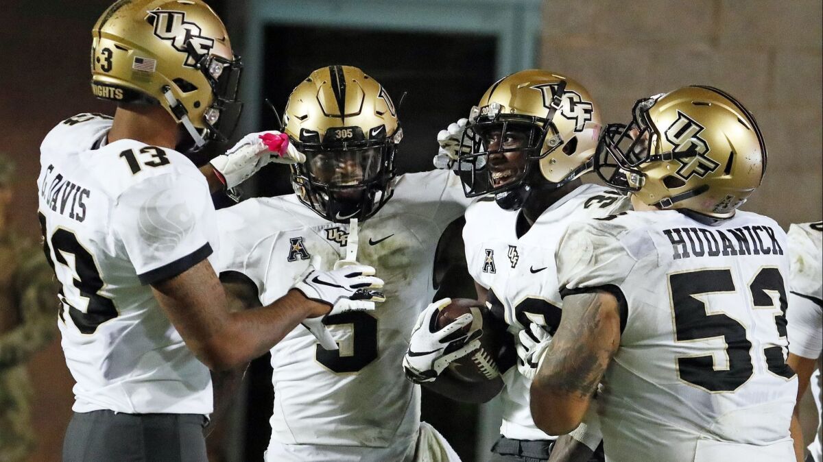 Central Florida's Alex Swenson, second from right, is congratulated by teammates after scoring a touchdown against East Carolina on Saturday. The Knights are undefeated in their last 20 games.
