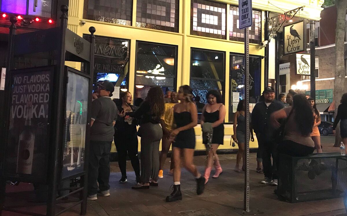 In this file photo from last weekend, Gaslamp Quarter visitors ignored social-distancing orders and didn't wear masks.
