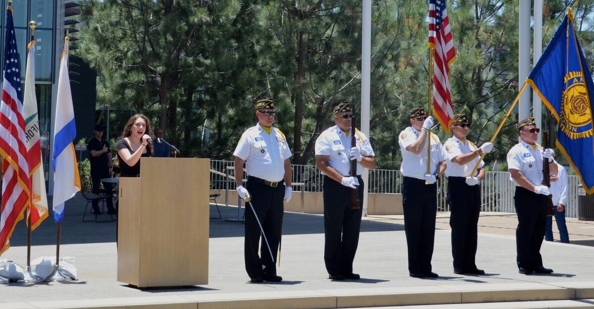 Keira Wilkes sings the national anthem alongside the American Legion Post 291 color guard Friday.