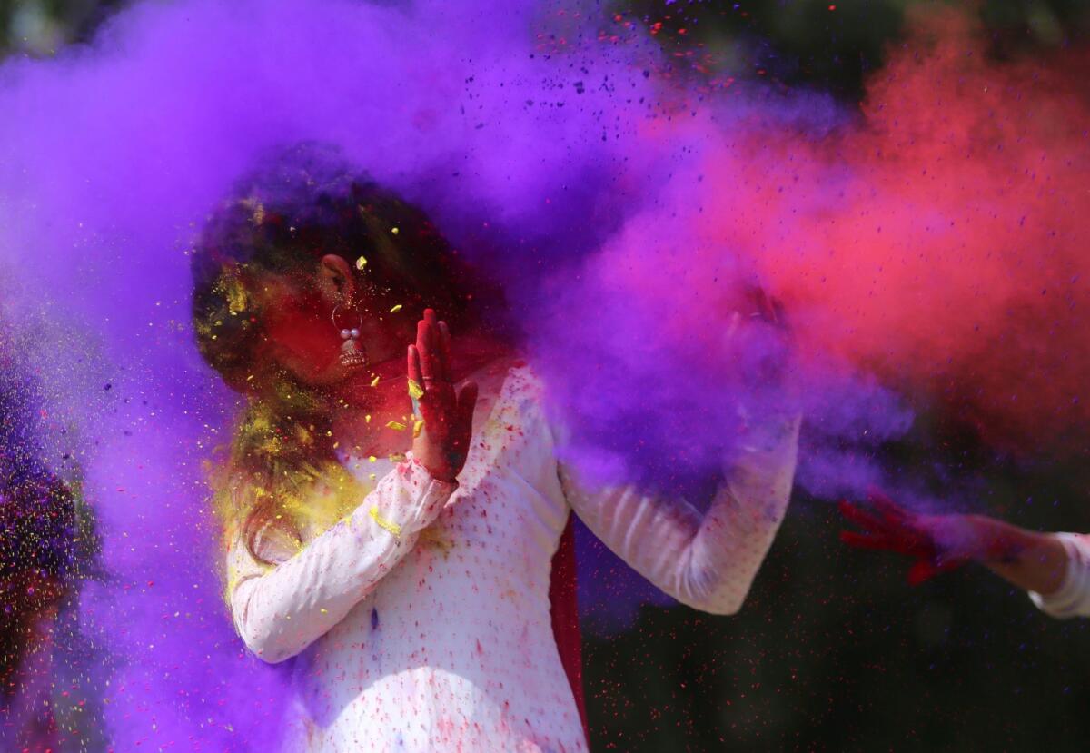 Indian college girls throw colored powder to one another during Holi festival celebrations in Bhopal, India.