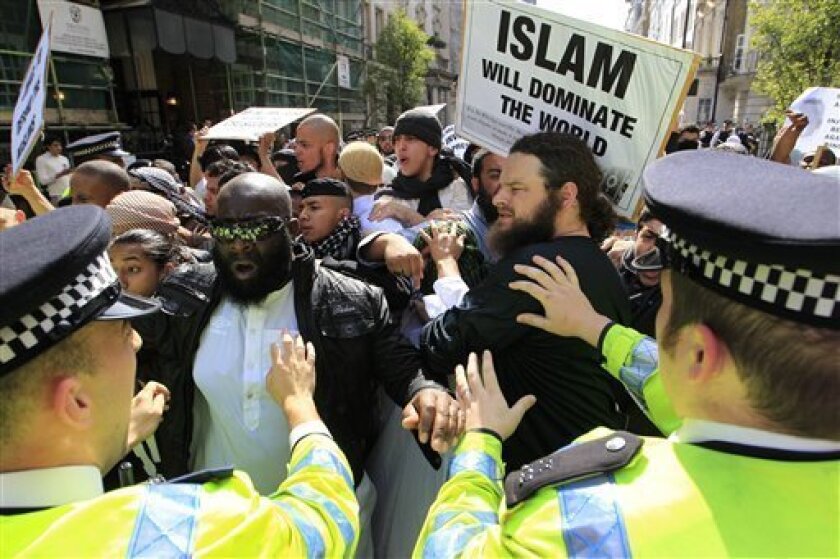 Police officers try to restrain pro-bin Laden supporters, marching to the U.S. Embassy in London to protest against the killing of Al-Qaida leader Osama Bin Laden by U.S.' special force in Pakistan, from supporters of the right-wing English Defense League, Friday, May 6, 2011.(AP Photo/Sang Tan)