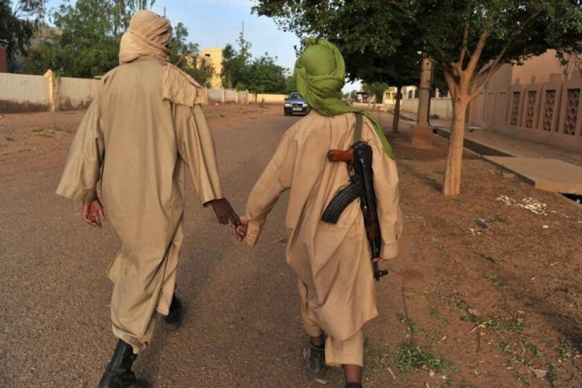 Fighters with the Islamist group Movement for Unity and Jihad in West Africa (MUJAO) walk through Gao, Mali.
