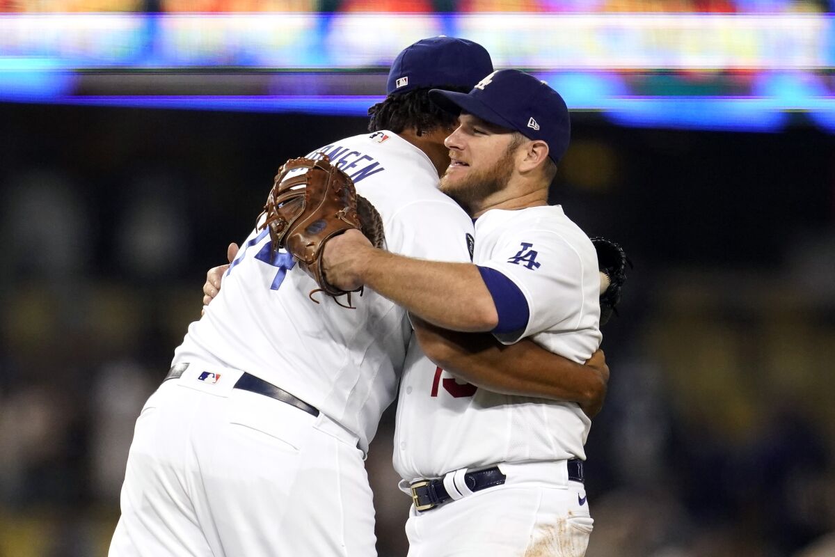 Los Angeles Dodgers relief pitcher Kenley Jansen, left, hugs Max Muncy after the Dodgers' 8-4 win over the Arizona Diamondbacks in a baseball game Tuesday, Sept. 14, 2021, in Los Angeles. (AP Photo/Marcio Jose Sanchez)