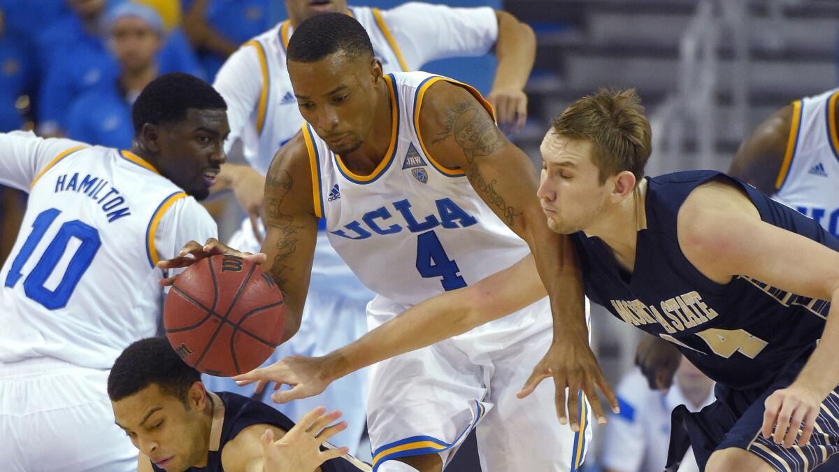 UCLA guard Norman Powell, center, grabs a loose ball away from Montana State guard Zach Green during the second half of the Bruins' season-opening win on Friday.
