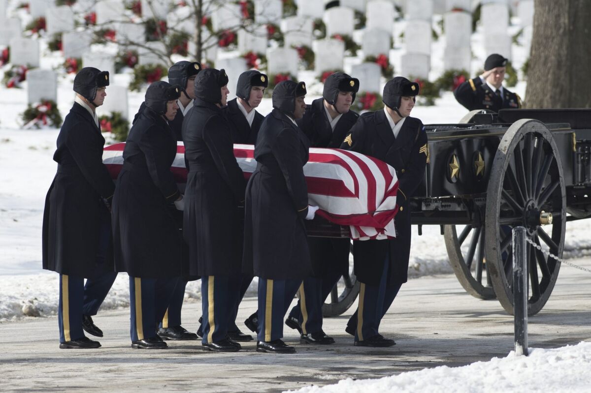 A casket team of the U.S. Army's 3rd Infantry Regiment carries the flag-draped coffin during the burial service at Arlington National Cemetery in January. A member of a funeral's honor team in the Wisconsin National Guard is under fire for what officials said were disrespectful comments that she made on social media about military funerals.