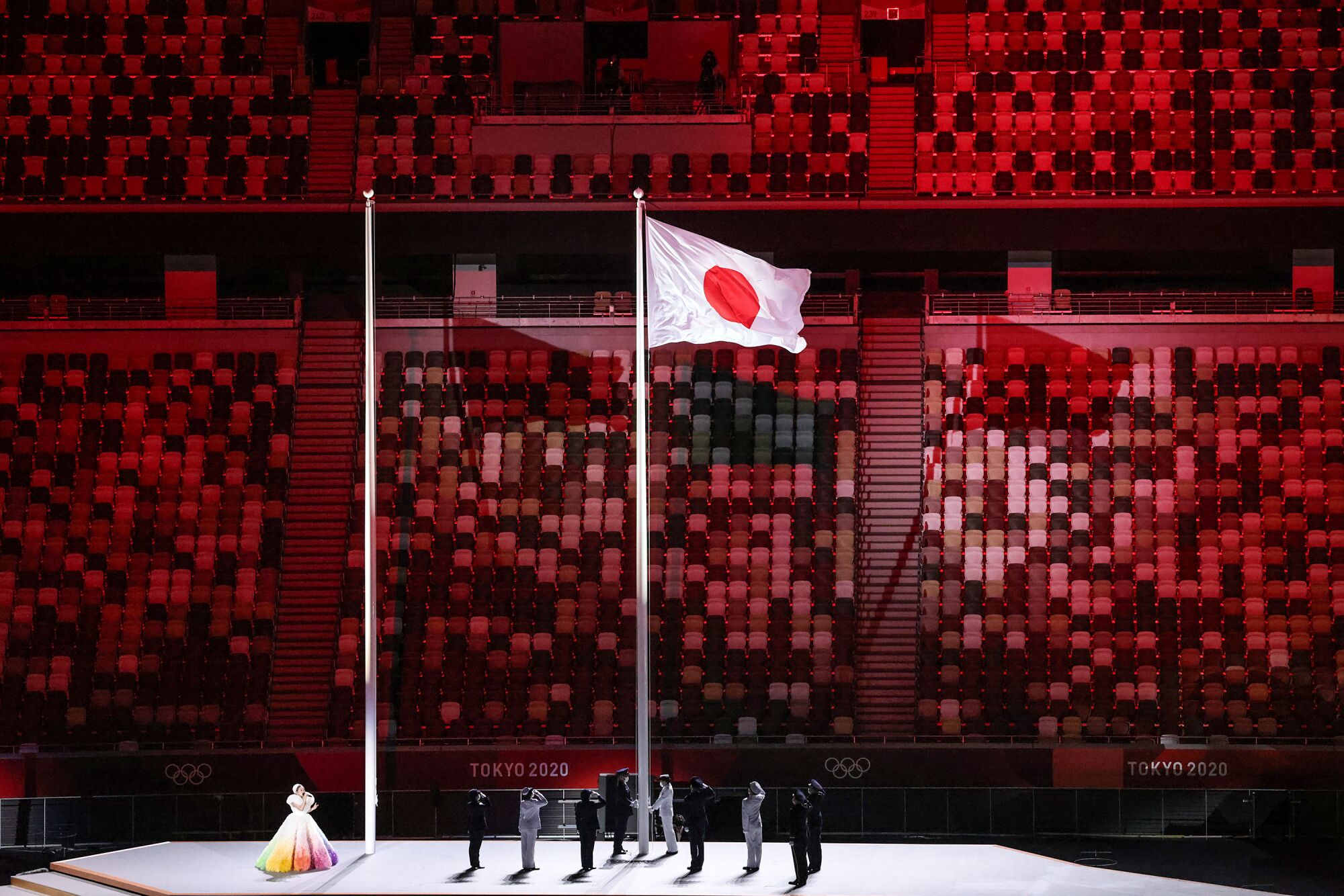 People stand on stage alongside the Japanese flag