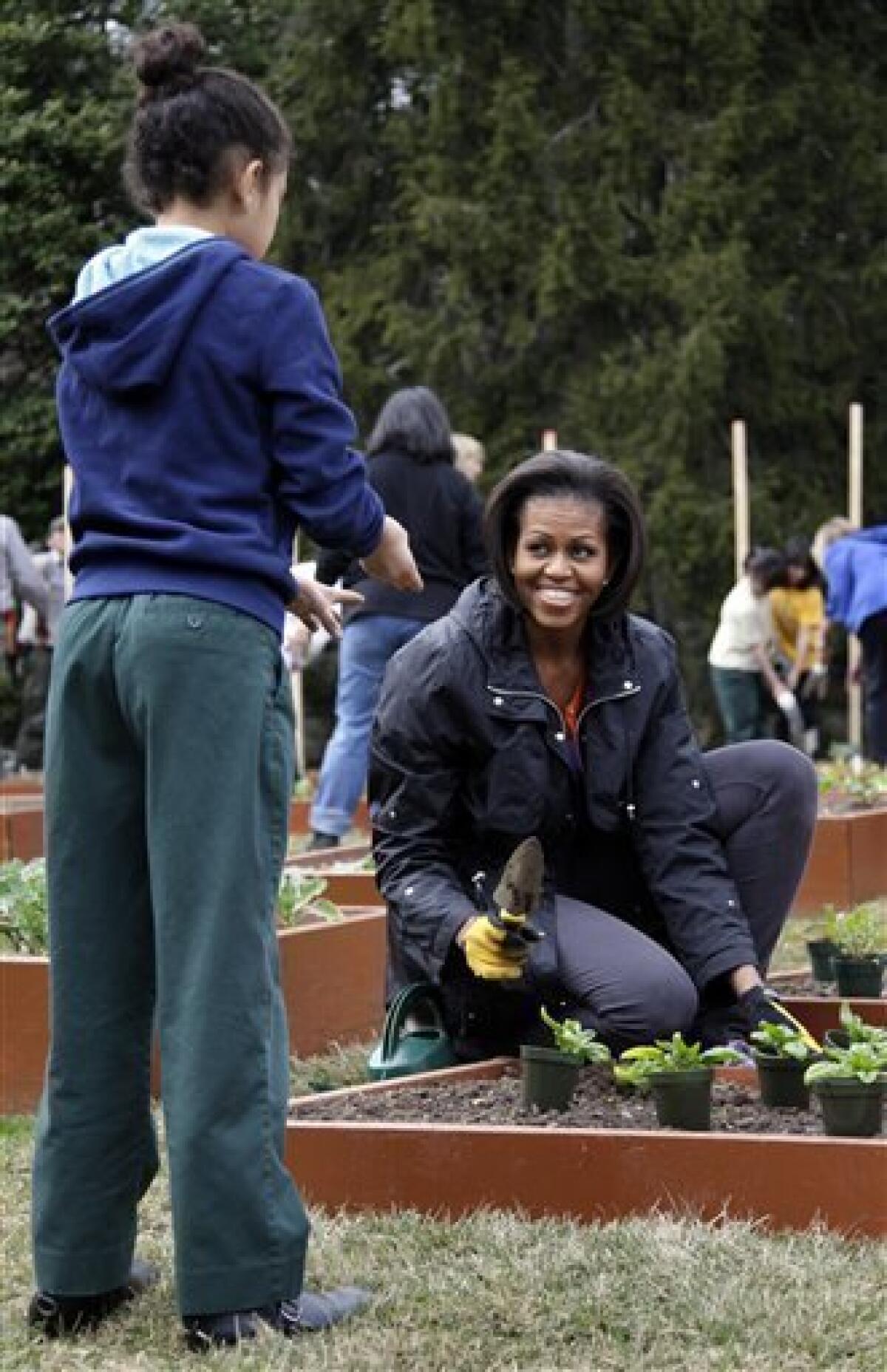 First lady Michelle Obama participates in the third planting of the White House kitchen garden with local school children at the White House, Wednesday, March 16, 2011, in Washington. (AP Photo)
