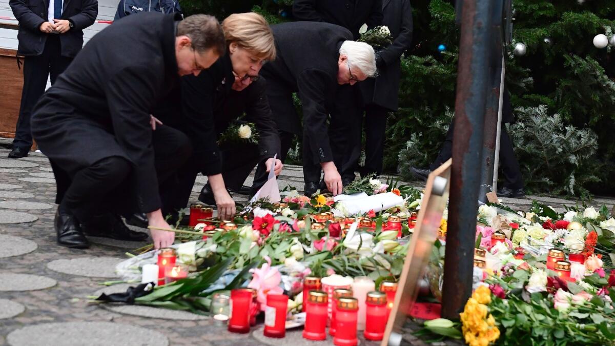 From left, Berlin Mayor Michael Mueller, German Chancellor Angela Merkel, Interior Minister Thomas de Maiziere and Foreign Minister Frank-Walter Steinmeier lay flowers on Dec. 20, 2016, at the site of an attack on a Christmas market in Berlin.