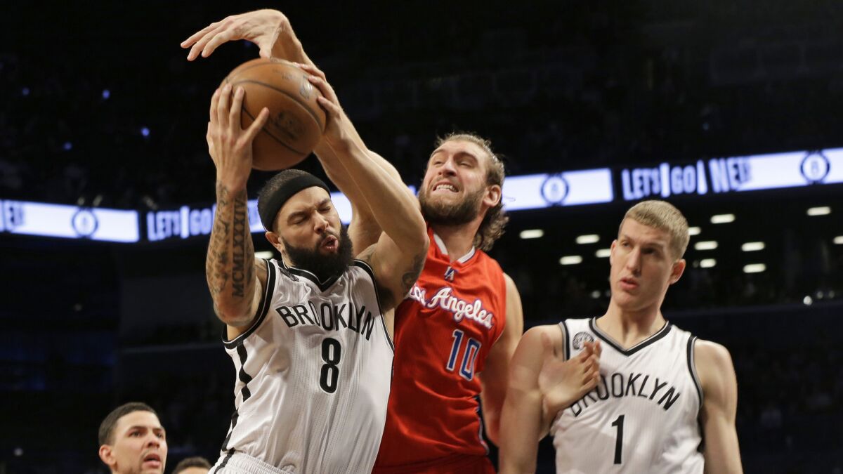 Clippers forward Spencer Hawes, center, tries to block a shot by Brooklyn Nets guard Deron Williams, left, as center Mason Plumlee looks on during the Clippers' 102-100 loss Monday.