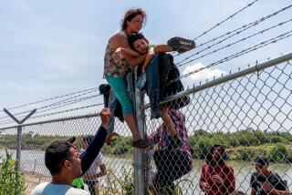 TOPSHOT - Migrants climb over a barbed wire fence after crossing the Rio Grande into US from Mexico, in Eagle Pass, Texas on August 25, 2023. (Photo by SUZANNE CORDEIRO / AFP) (Photo by SUZANNE CORDEIRO/AFP via Getty Images)