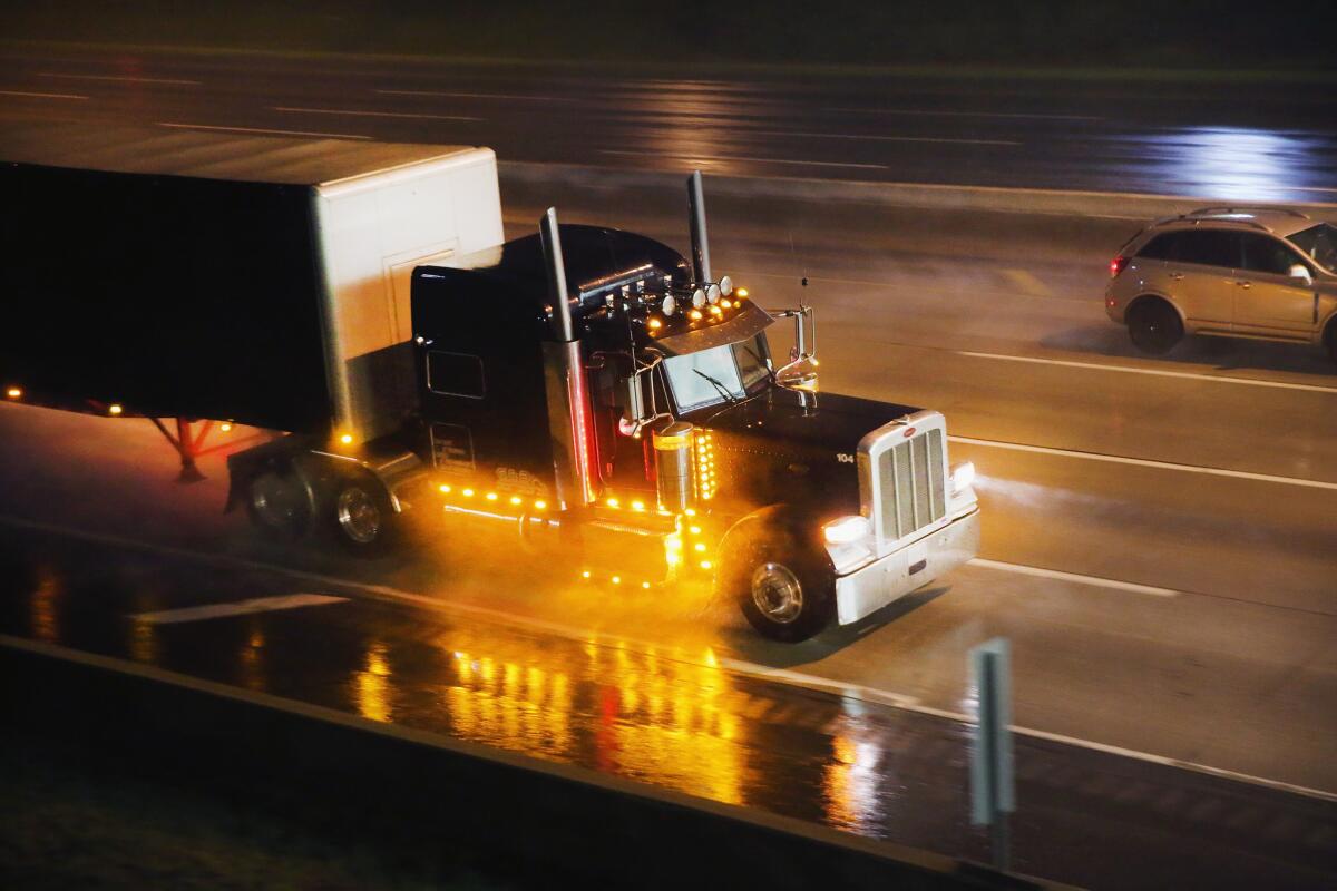 A truck driver navigates a rain-covered highway on the outskirts of Chicago.