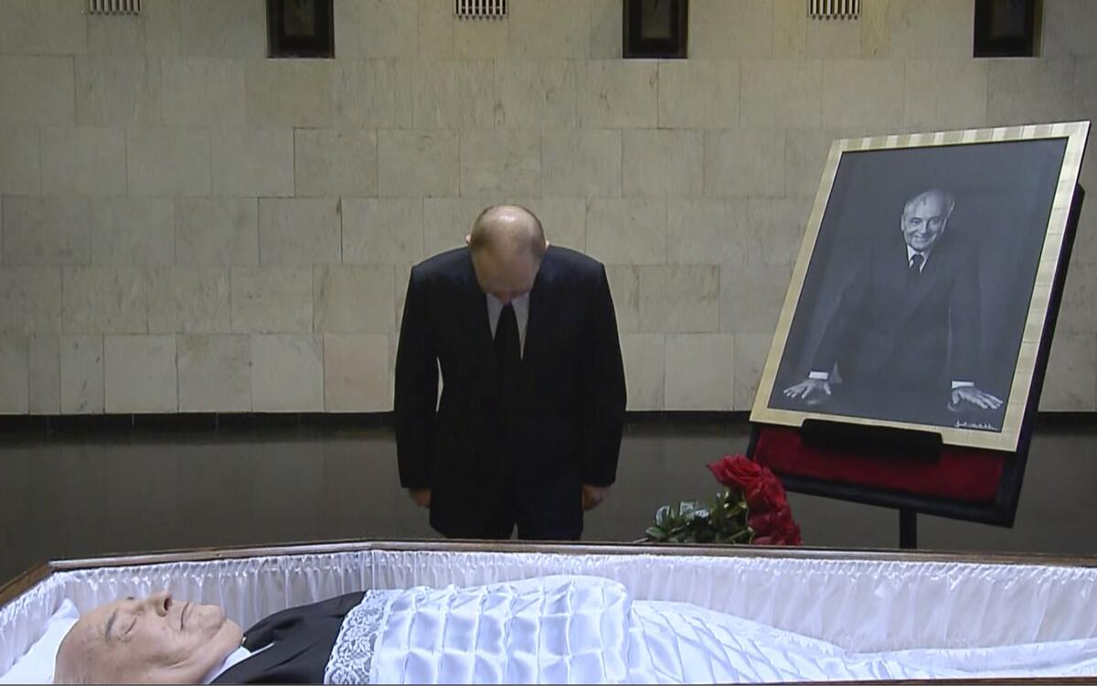 Russian President Vladimir Putin bowing his head before the coffin and body of former Soviet leader Mikhail Gorbachev