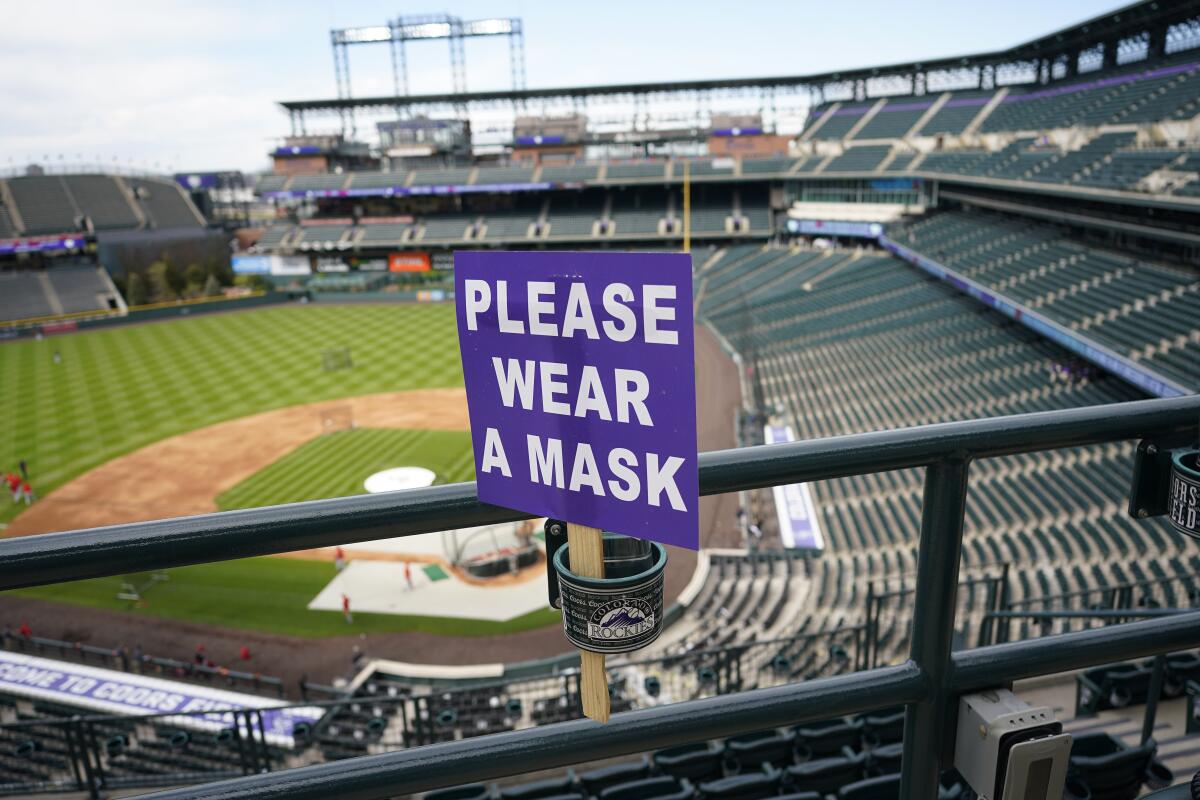 Esta fotografía muestra un letrero que pide a los aficionados portar una mascarilla en el estadio Coors Field