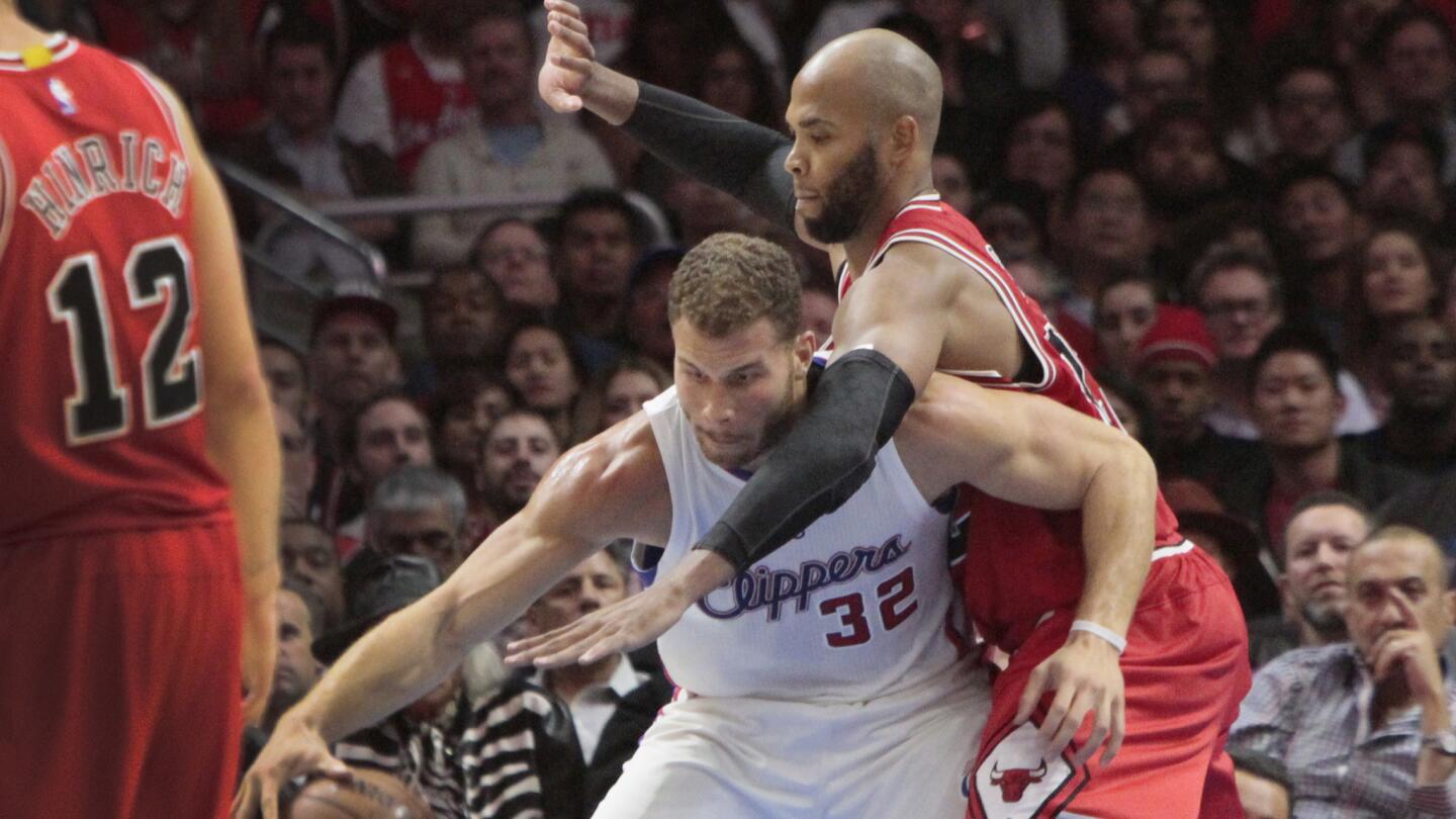 Clippers forward Blake Griffin, left, is pressured by Chicago Bulls forward Taj Gibson during the second half of the Clippers' 105-89 loss Monday at Staples Center.