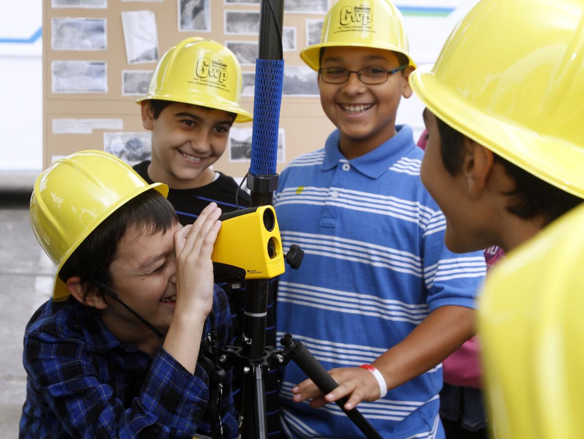 With classmates looking on, Armand Martin of Keppel Elementary School looks through a GPS device at the Glendale Water and Power Plant at 800 Air Way in Glendale on Thursday, Oct. 24, 2013.