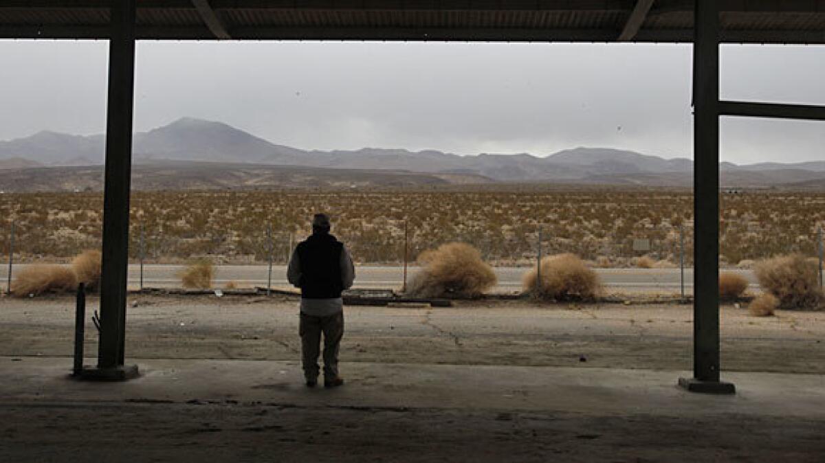 Realty agent Larry Cullinane stands at abandoned truck scales and looks at 400 acres in the Mojave Desert that he would like to sell as a potential solar site.