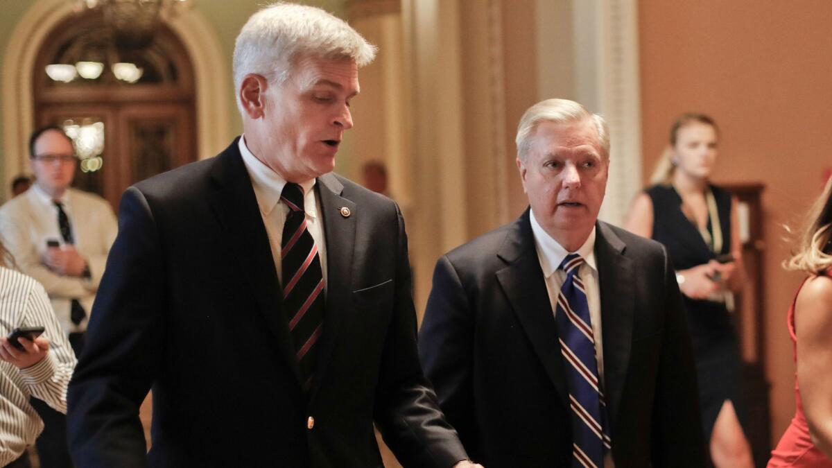 GOP Sens. Bill Cassidy of Louisiana, left, and Lindsey Graham of South Carolina confer on their last-minute measure to repeal the Affordable Care Act.