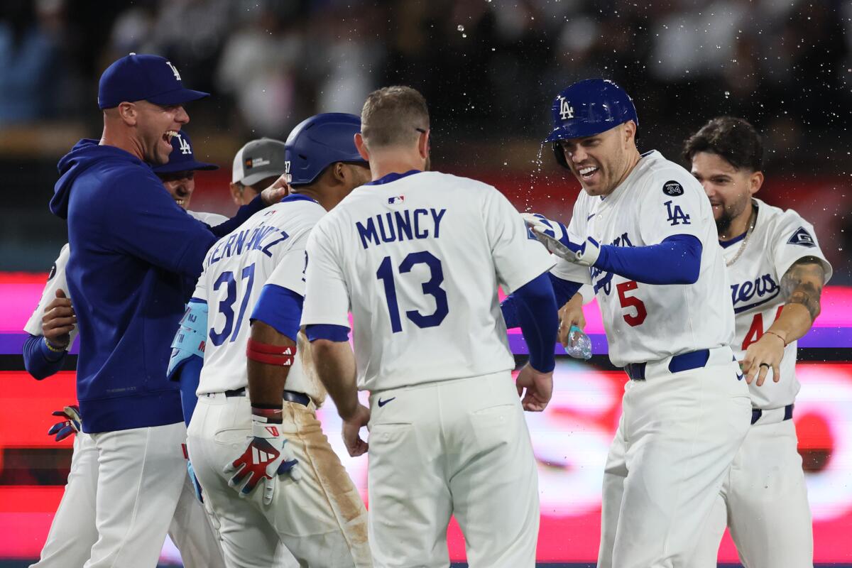 Freddie Freeman is mobbed by teammates after hitting a walk-off double against the Mets.