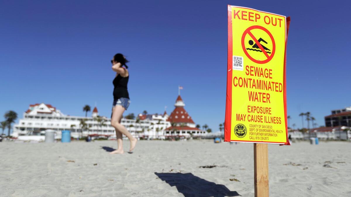 A sign warns of sewage contaminated ocean waters on a beach in front of the iconic Hotel del Coronado on Wednesday, March 1, 2017, in Coronado, Calif.