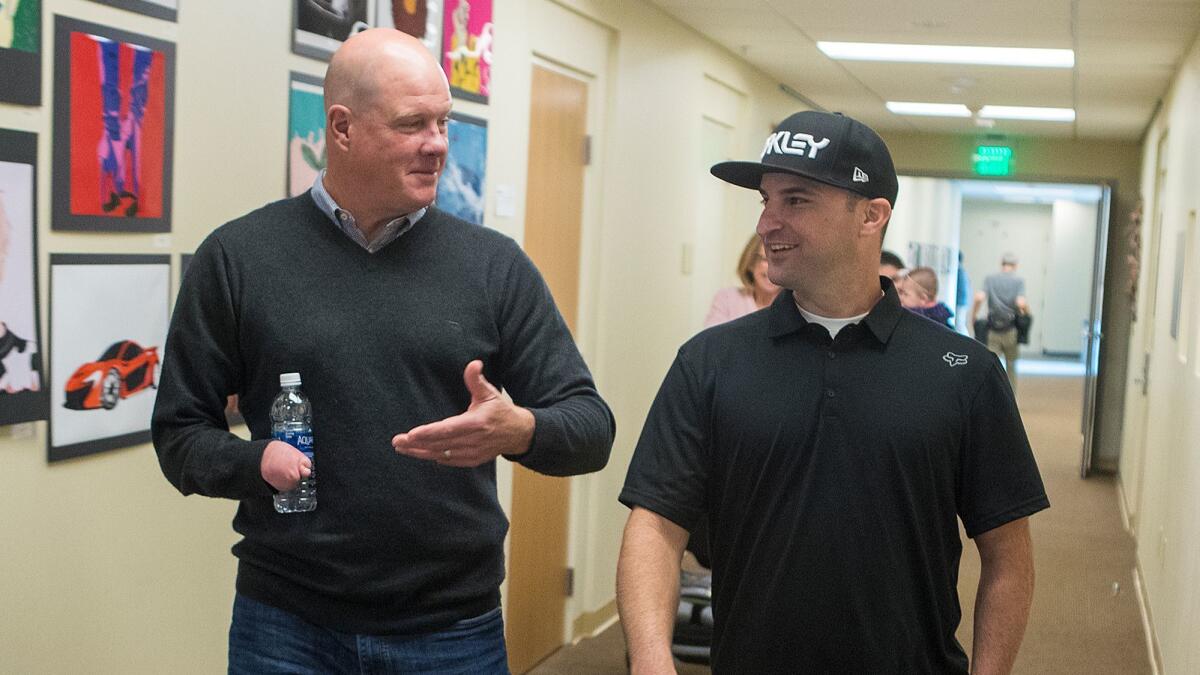 Former major-league pitcher Jim Abbott, left, who was born without a right hand, and Stephen Ley, who was born without four fingers on his left hand, talk after speaking to students at Sage Hill School in Newport Coast on Wednesday.