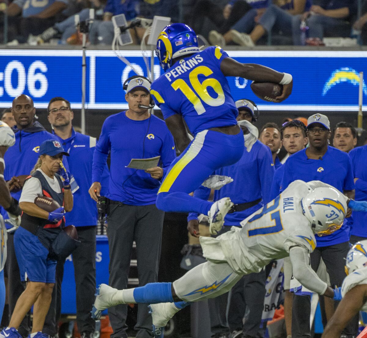 Rams quarterback Bryce Perkins jumps over Chargers cornerback Kemon Hall during a preseason game Saturday at SoFi Stadium.