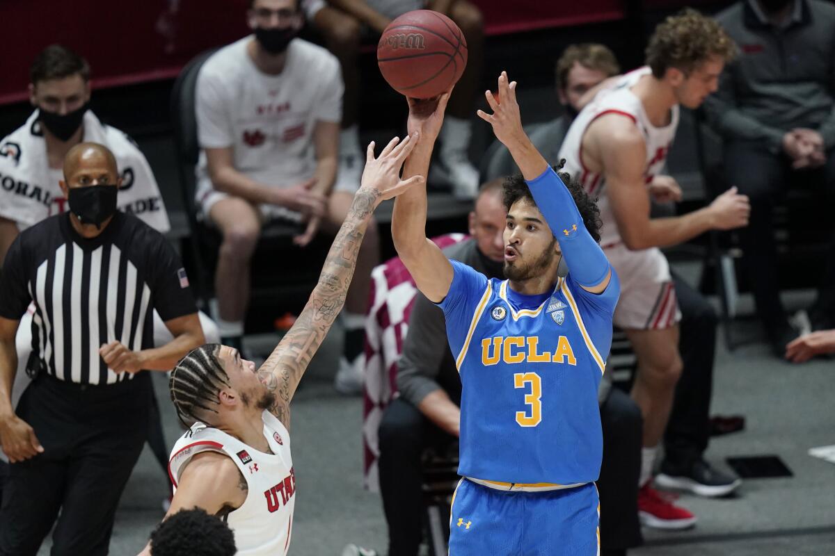 UCLA guard Johnny Juzang shoots as Utah forward Timmy Allen defends.