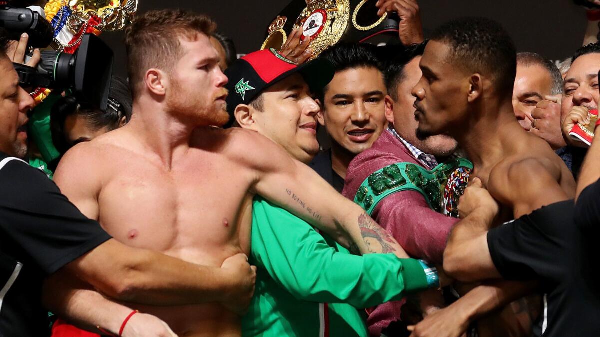 Canelo Alvarez, left, and Daniel Jacobs get into a shoving match during their official weigh-in at T-Mobile Arena in Las Vegas on May 3.