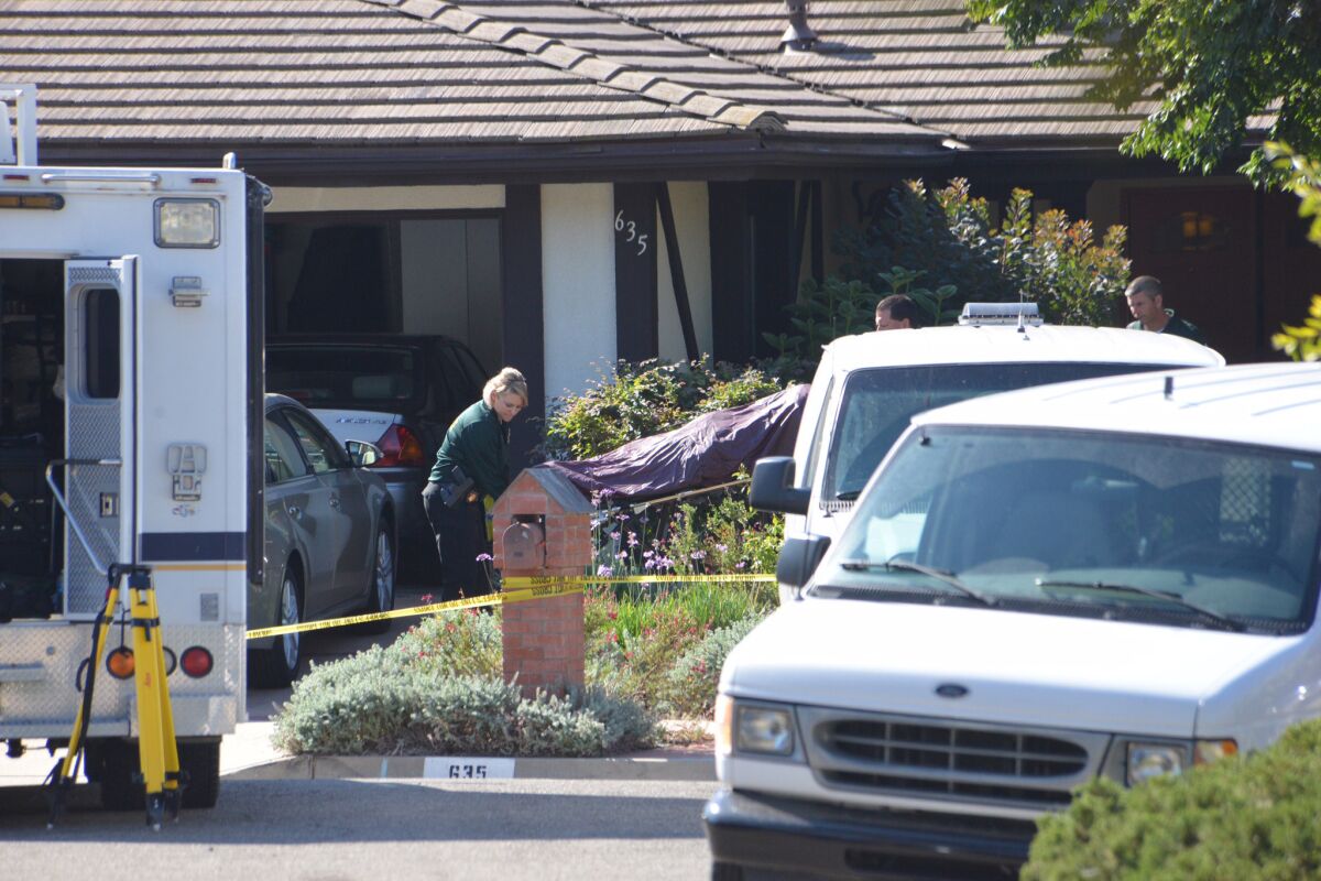 Investigators remove a body from a Santa Barbara County home where four people were found stabbed to death.