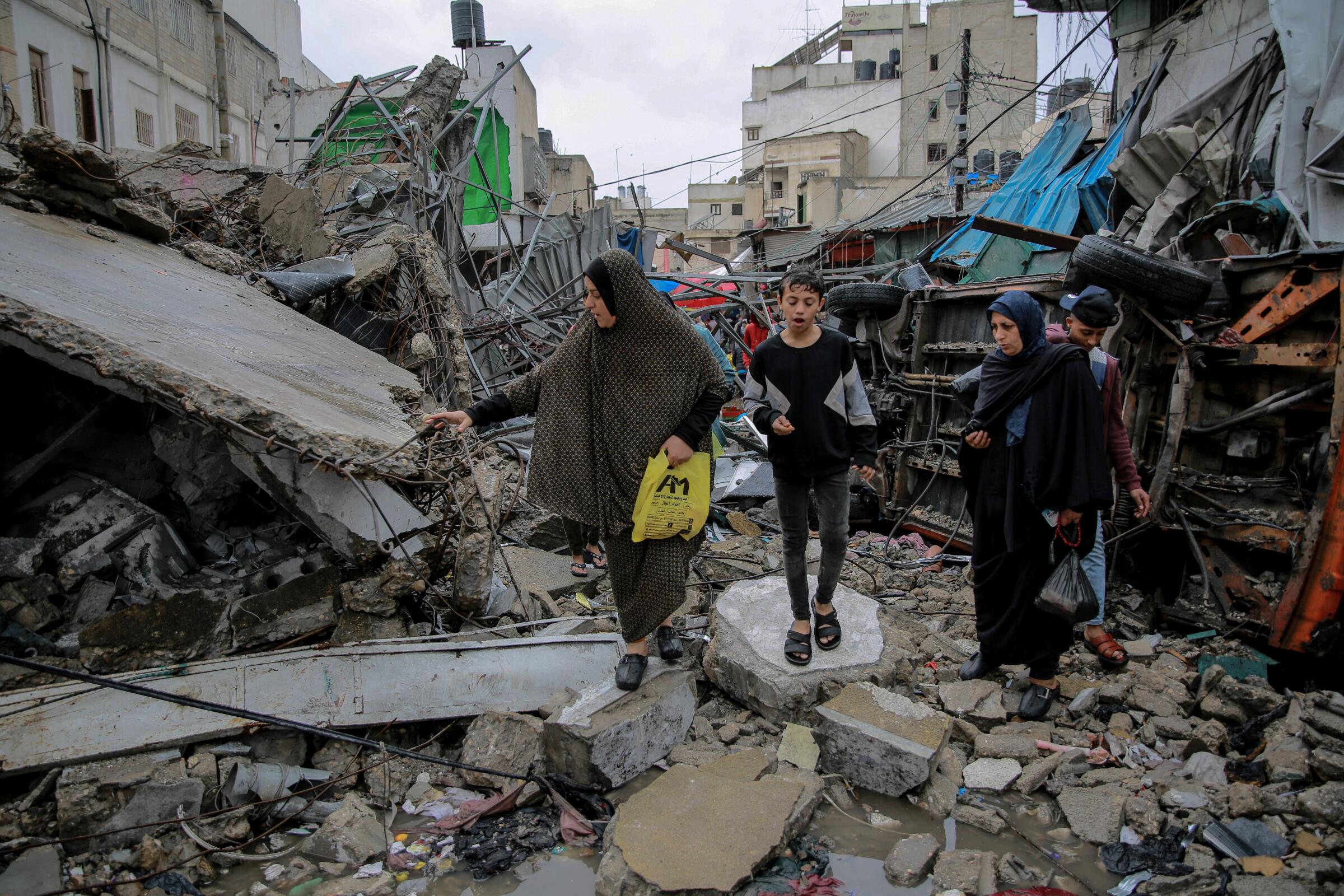 People walk amid the rubble of buildings 