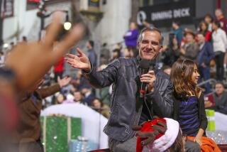 Hollywood, CA - November 27: A person gives outgoing Los Angeles Mayor Eric Garcetti, shown with daughter, Maya Juanita Garcetti, the peace sign while riding in The 90th anniversary Hollywood Christmas Parade in Hollywood Sunday, Nov. 27, 2022. (Allen J. Schaben / Los Angeles Times) Actor Danny Trejo served as grand marshal of the parade, which will also feature dozens of movie and TV stars and other celebrities, movie and novelty cars, balloons, marching bands and city officials. Parade hosts include Erik Estrada, Laura McKenzie, Dean Cain, Montel Williams, special co-host Elizabeth Stanton.