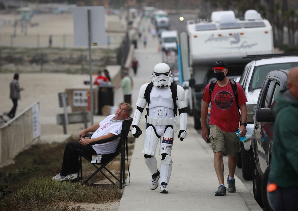 Jeffry Priela, 38, of Carlsbad, walks down Highway 101 Sunday during a fundraisin "ruck" in his Star Wars stormtrooper armor.