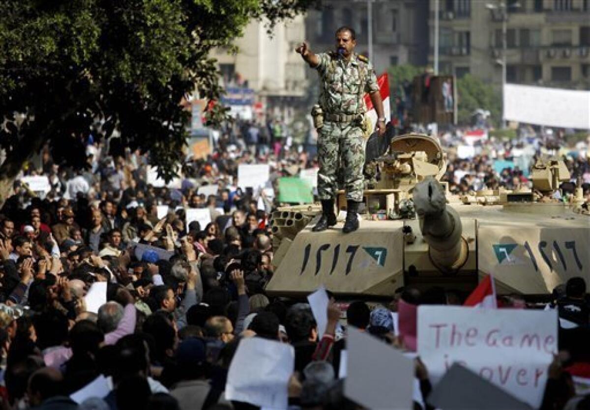 An Egyptian army Lieutenant Colonel stands atop a tank as the crowd arrives to Tahrir, or Liberation, Square in Cairo, Egypt, Tuesday, Feb. 1, 2011. More than a quarter-million people flooded into the heart of Cairo Tuesday, filling the city's main square in by far the largest demonstration in a week of unceasing demands for President Hosni Mubarak to leave after nearly 30 years in power. (AP Photo/Emilio Morenatti)