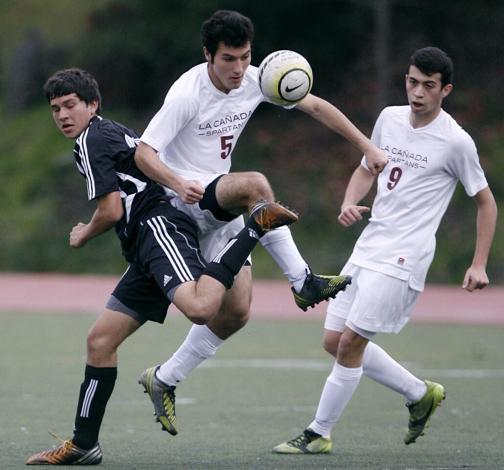 La Canada High School's #5 Shant Hairapetian battles for the ball vs. South Pasadena High School's #17 Daniel Zurita during home game in La Canada on Wednesday, January 23, 2013. LCHS #9 is Armaan Zare.