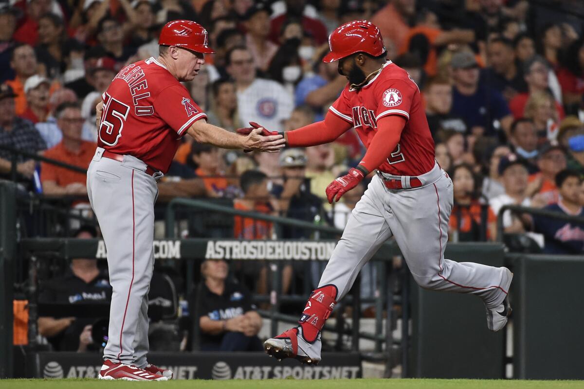 The Angels' Luis Rengifo celebrates his two-run homer with third base coach Brian Butterfield on Sept. 11, 2021.