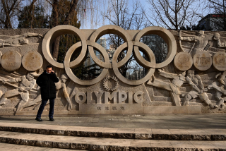 A man uses his mobile phone in front of an Olympic installation at the Olympics Community Museum in Beijing.