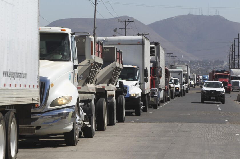 Commercial trucks wait in line to cross at the Otay Mesa Port of Entry in this 2019 file photo.