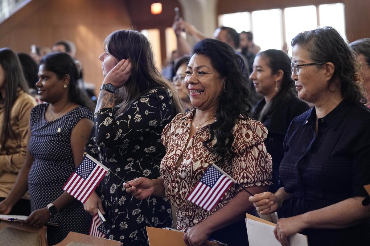 People hold flags at a naturalization ceremony 