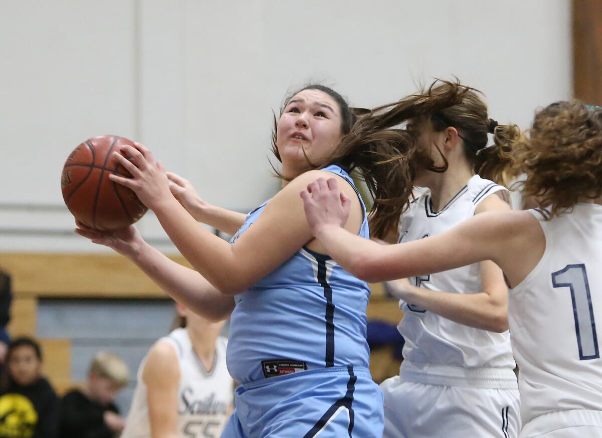 Corona del Mar's Makena Tomlinson grabs a bounce pass and turns for a layup in the Battle of the Bay rivalry game at Newport Harbor on Thursday.