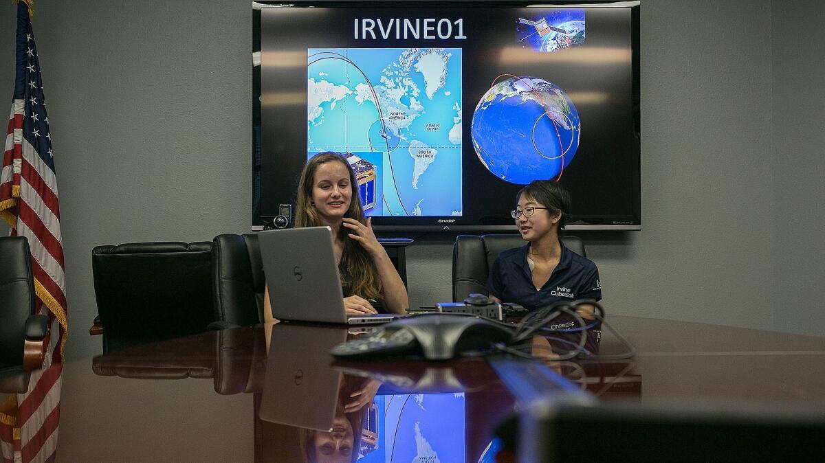 Morgan Kopecky, 16, left, and Sarah Shimizu, 15, talk about the communications system for the CubeSat on July 26.