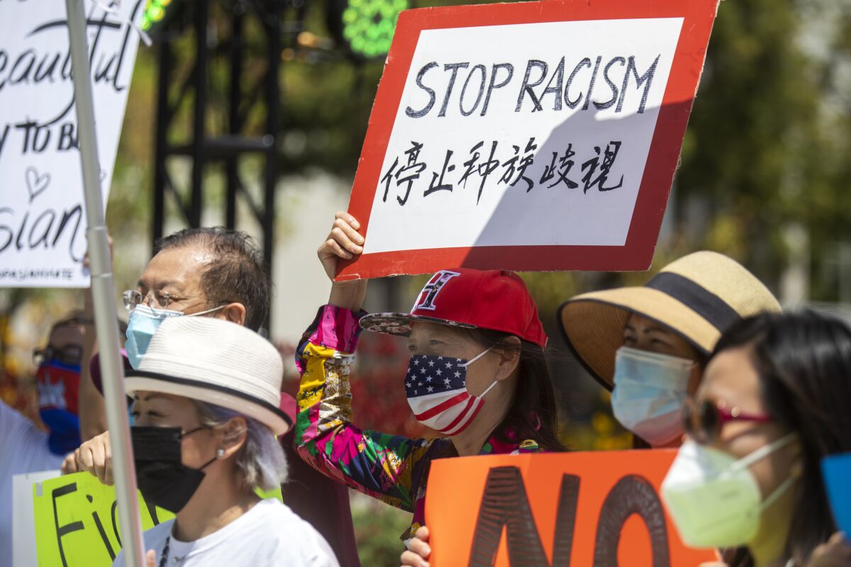 People hold signs at a rally