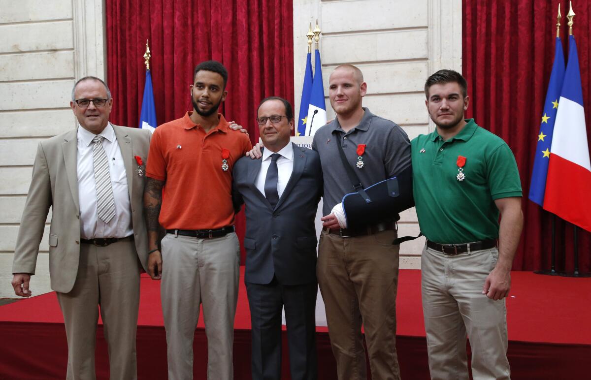 French President Francois Hollande, center, stands with, from left, British businessman Chris Norman and Americans Anthony Sadler, Spencer Stone and Alek Skarlatos, who subdued a gunman aboard a train. The four were awarded the Legion of Honor medal at the Elysee Palace on Aug. 24.