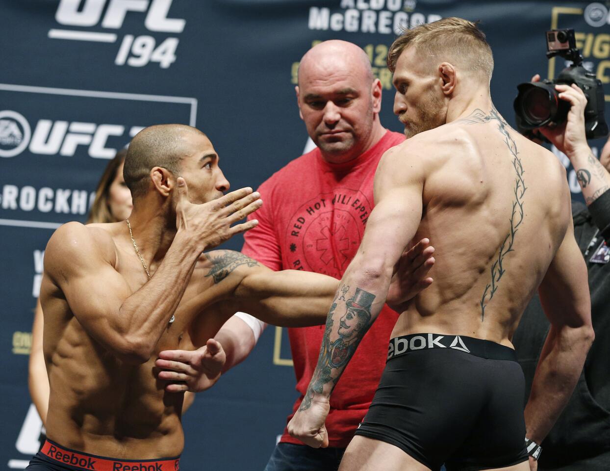 UFC president Dana White, center, stands between Conor McGregor, right, and Jose Aldo during the weigh-in for UFC 194, Friday, Dec. 11, 2015, in Las Vegas. McGregor and Aldo are scheduled to fight in a featherweight championship bout Saturday in Las Vegas. (AP Photo/John Locher)