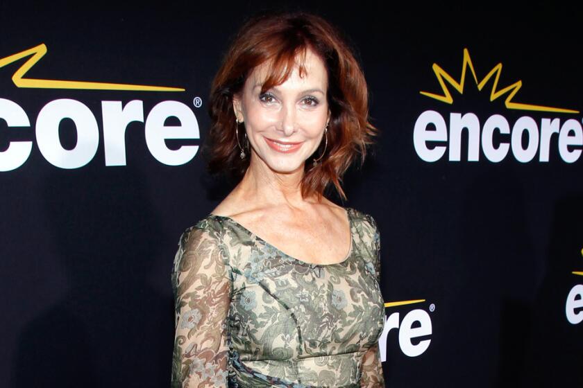 Jill Jacobson in a sheer green dress smiling and posing against a black background with white text