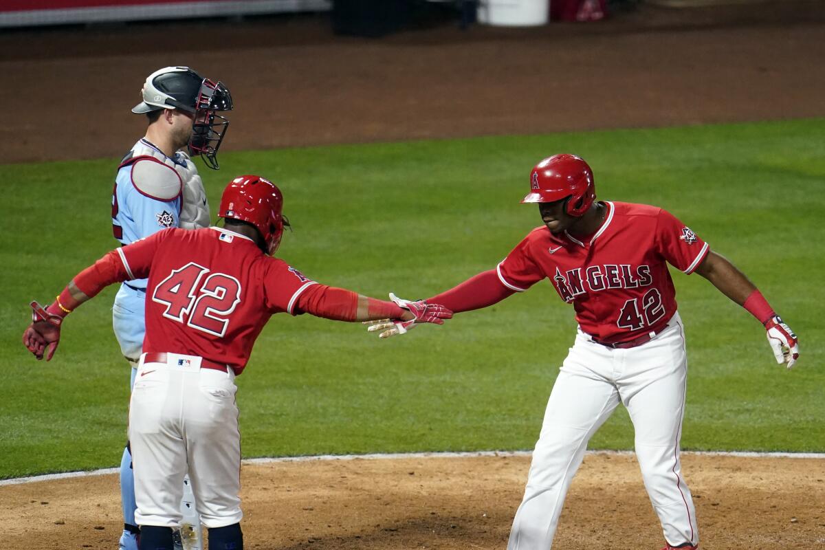 The Angels' Justin Upton celebrates his grand slam at home plate with Luis Rengifo.