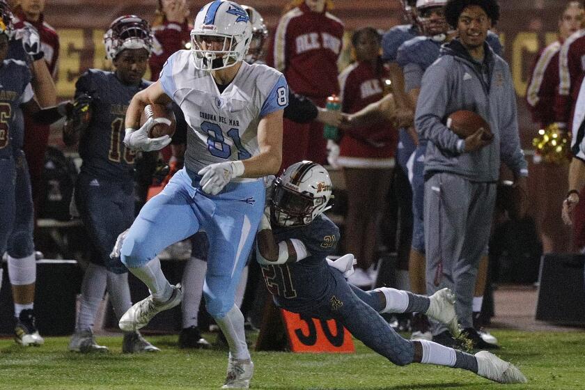 Corona del Mar's Mark Redman drags Alemany defender Elijah Gipson after a pass and run for a first down in a CIF Southern Section Division 3 semifinal football game at Bishop Alemany High School in Mission Hills on Friday, November 22, 2019.