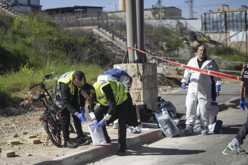 Fuerzas de seguridad israelíes inspeccionan el lugar de un apuñalamiento en un control de seguridad entre Jerusalén y Cisjordania el miércoles 13 de marzo de 2024. Un palestino apuñaló e hirió a dos personas en un control cerca de Jerusalén antes de morir baleado. (AP Foto/Mahmoud Illean)