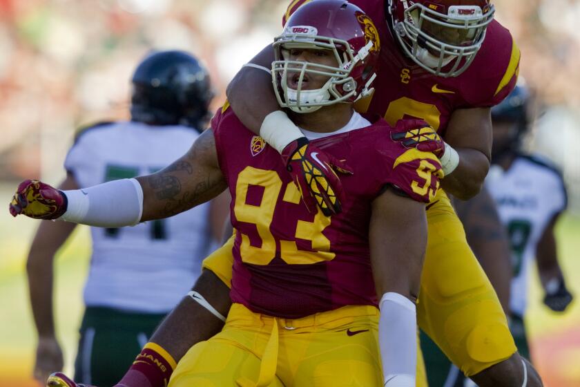 USC defensive end Greg Townsend Jr., bottom, is congratulated by teammate Hayes Pullard after a sack in 2012.